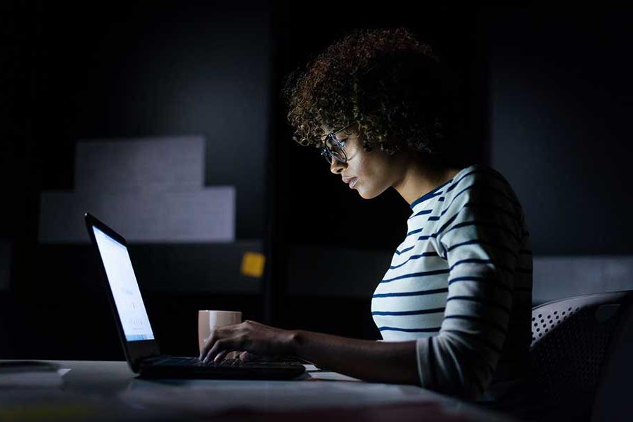 Individual working on a computer at night